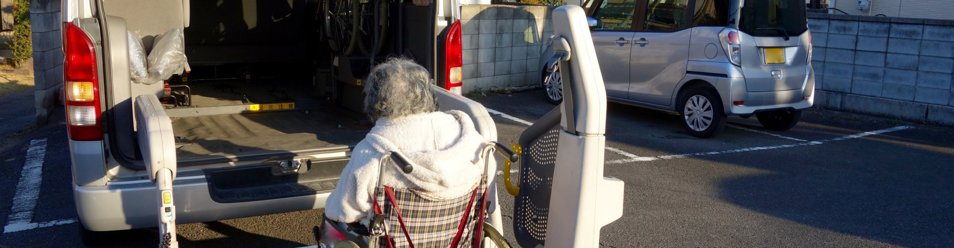 senior citizen is transferred by a vehicle with a lift